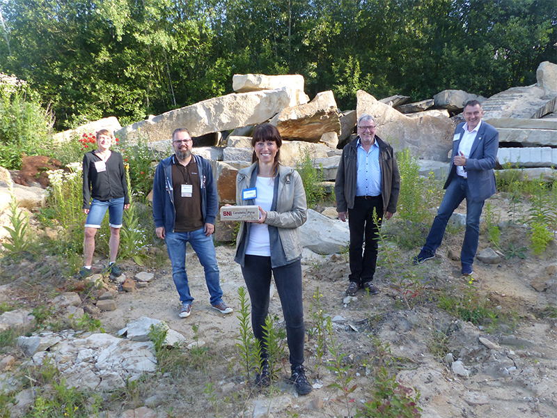 Führungswechsel im Steinbruch. v.l.n.r. Sandra Giza, Jens Scholtyschik, Lisa Biber mit dem Staffelstab aus Sandstein, Rechtsanwalt Wolf-Dieter Ernicke und BNI-Regionaldirektor Jens Fiedler